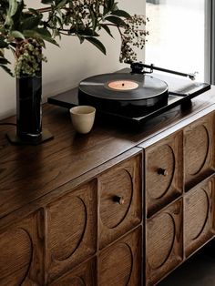 a record player on top of a wooden dresser