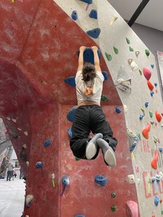 a woman climbing up the side of a rock wall