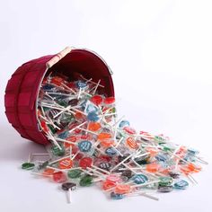 a bucket filled with lots of candy sitting on top of a pile of lollipops