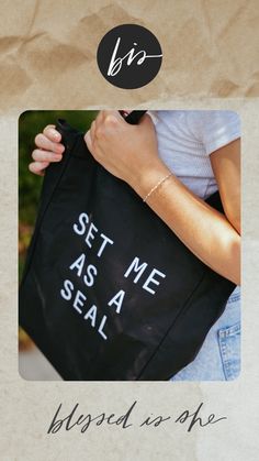 a woman holding a black bag with white writing on it and the words, set me seal