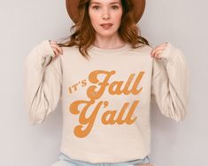 Its Fall Yall Shirt | Retro Fall Crewneck Sweatshirt | Pumpkins Fall Sweatshirts | Autumn Sweatshirt This Retro Fall Sweatshirt was designed with love from the Blue Ridge Mountains by Grace @GraceCreatedCo.  FIT - Unisex, Classic Fit FEATURES - Direct-To-Garment Printing. No vinyl stickers, no cracking or peeling of the design. Double needle stitching. Ribbed knit collar. MATERIALS - Cotton/Poly Blend CARE - Machine wash cold, inside out. Do not dry clean, blech or iron directly over design. Tum Fall Cotton Slogan Sweatshirt, Cotton Slogan Sweatshirt For Fall, Casual Fall Tops With Lettering, Trendy Fall Tops With Lettering, Trendy Fall Tops With Graphic, Trendy Tops With Lettering For Fall, Fall Cotton Sweatshirt With Lettering, Cotton Sweatshirt With Lettering For Fall, Long Sleeve Hoodie With Lettering For Fall