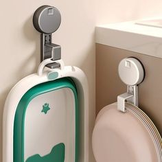 a green and white urinal sitting next to a wall mounted toilet paper dispenser