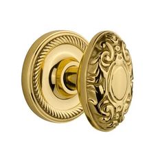 an ornate brass door knob with a decorative design on the front and side, shown from the