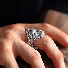 This incredible tyrannosaurus rex head ring is made in sterling silver. We have carefully made the teeth and skin details to create a more realistic effect. Dimensions: 21mm X 21mm X 23mm. These measurements may vary depending on the size of the ring. Other sizes available only on request. If you have any questions about your ring size, do not hesitate to contact us. Dinosaur Stuff, Dinosaur Ring, Dinosaur Jewelry, Dinosaur Head, Masc Outfits, Skin Details, Biker Rings, Head Ring, Tyrannosaurus Rex