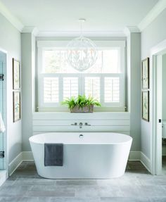 a white bath tub sitting under a window next to a sink