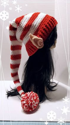 the doll is wearing a red and white striped hat