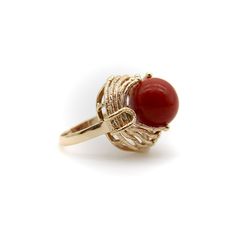 This is part of Chairish’s Fine Jewelry assortment.  At Kirsten’s Corner we love vintage coral, and this ring centers around a 12mm round sphere of well-saturated deep red Sardinian coral. The ball is centered in a tentacle-like circular mount that flows from its base and grasps the coral ball in a beautiful sci-fi fashion.  The 14k gold tentacles have a textured matte surface, ending in tiny golden balls that come together on either side of the sphere like finger tips on a hand. Circa the 1970’s, this is a great conversation piece that is both unique and elegant.   The ring is marked as 14k. It weighs 7.41 grams. The circular element measures 3/4” and the ring rises up 1/2” high on the finger. Made in Italy.   Ring size 5. Classic Round Coral Jewelry, Classic Coral Round Jewelry, Elegant Coral Rings For Anniversary, Elegant Coral Ring Jewelry, Formal Coral Ring, Formal Red Dome Ring, Coral Elegant Wedding Rings, Elegant Coral Wedding Rings, Elegant Red Dome Ring For Anniversary