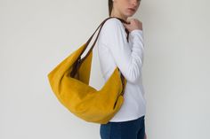 "DeLuna is a collection of large suede handbags for women who love to carry slouchy purses. Featured in this listing in mustard suede leather, it has plenty of room for all your essentials which makes it the perfect carryall bag. The contrast of the two-tone colors on the straps and on the main body is what makes the design unique and stand out. The straps sit comfortably on your shoulder and the bag is secured with a top zipper closure. Inside the bag, there is one main compartment with a large Slouchy Purse, Soft Leather Bag, Suede Handbags, Leather Conditioner, Leather Hobo Bag, Carry All Bag, Leather Hobo, Handbags For Women, Medium Bags