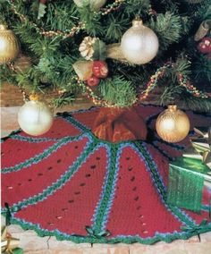 a crocheted christmas tree skirt with ornaments around it