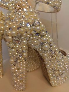 a pair of high heeled shoes made out of pearls