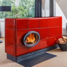 a red fire place sitting in the middle of a living room next to a window