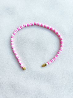 Handcrafted white and pink beaded anklet/bracelet. Made using small colourful round glass beads and finished with a gold-plated barrel clasp closure. Pair it with our matching Necklace.  * Weight: 7g   * Width: 5mm/2mm  * Made in UK  * Code: 111AWPS The very best in unique, handmade pieces from BAM-BAM, our anklets and bracelets make great accessories for the beach, festival or club. These small beads have a dainty appearance and can take your best looks from day to night. Adjustable Pink Heishi Beads, Adjustable Pink Anklet With Colorful Beads, Adjustable Pink Single Strand Beaded Bracelets, Adjustable Pink Single Strand Beaded Bracelet, Adjustable Single Strand Pink Beaded Bracelet, Pink Heishi Beads For Beach, Pink Round Beaded Bracelets For Beach, Pink Spacer Beads For Beach, Single Strand Pink Round Beads