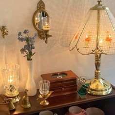 a table topped with vases filled with flowers next to two wall sconces