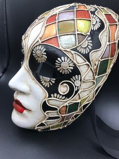 "Size: one size Traditional and original papier-mache Venetian mask, handmade and decorated with trimmings, stucco and acrylics. This traditional Venetian mask shape is called \"Volto mask\" and is a full face mask. This mask remembers Harlequin for the style of the decoration and its coloros. All our masks are handmade papier-machè masks, made in Venice. Our decorators use techniques typical of the Venetian tradition such as stucco, acrylics, gold and silver-leaf, macramè, passementerie, pearls Handmade Artistic Masks For Carnival, Venetian Multicolor Masquerade Mask, Artistic Multicolor Masquerade Mask For Carnival, Artistic Multicolor Masquerade Mask For Mardi Gras, Artistic Multicolor Masks For Carnival, Artistic Multicolor Masquerade Masks, Artistic Masks And Prosthetics For Mardi Gras, Artistic Multicolor Masks For Masquerade, Artistic Full Face Masks For Carnival