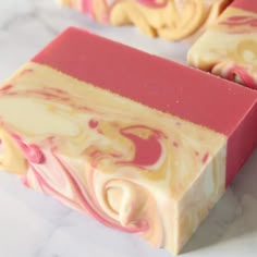 some pink and yellow soaps on a white table