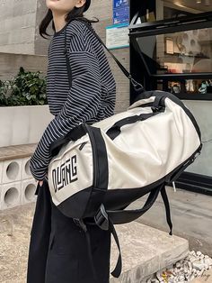 a woman carrying a duffel bag on the street