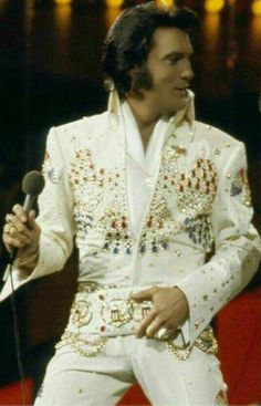 elvis presley singing into a microphone on stage