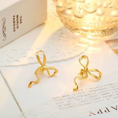 Who says everyday can't be charming? Gold Bow Earrings bring the coquette aesthetic with their classic ribbon design, meticulously designed with gleaming gold. Lightweight and comfortable, these high-quality earrings boast a smooth, shiny finish and long-lasting color. Effortlessly versatile, they pair perfectly with any outfit. Get ready to transform your everyday look from ordinary to oh-so-cute! DETAILS Plating: 18k Gold  Materials: 18k Gold on 925  Sterling Silver Size: 1.18"*0.98"(3.0cm*2.5 Delicate Gold Earrings For Party, Gold Earrings With Decorative Bow As Gift, Gold Earrings With Decorative Bow For Formal Occasions, Formal Gold Earrings With Decorative Bow, Elegant Gold Jewelry With Butterfly Knot, Elegant Gold Jewelry With Ribbon, Gold Wedding Jewelry With Butterfly Knot Detail, Elegant Yellow Gold Jewelry With Ribbon, Decorative Bow Drop Earrings For Gift