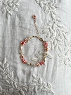 a pink beaded bracelet on a white tablecloth