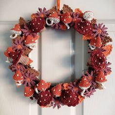 a crocheted wreath hangs on the front door with an orange ribbon hanging from it