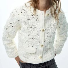 a woman is wearing a white cardigan sweater