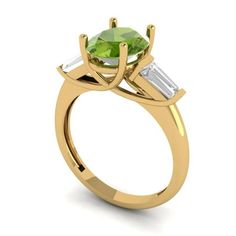 a yellow gold engagement ring with two baguets on the side and an oval cut green