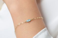 14k gold evil eye bracelet, a delicate, distinctive design of the classic evil eye.  The charm is attached to a chain type that gives you a mesmerizing shine with each movement. The chain is made with special cut links which are large enough to adjust the size of the bracelet to your liking( please see the last picture). 💎Design: Evil eye bracelet 💎 Material: Solid 14k Gold and E-coating for extra protection against tarnish and scratches , which will keep your bracelet looking spotless 💎Brace 14k Gold Bracelets With Evil Eye, Minimalist 14k Gold Evil Eye Bracelet, Dainty 14k Gold Evil Eye Bracelets, Dainty 14k Gold Bracelet With Evil Eye, Minimalist 14k Gold Evil Eye Bracelet Gift, Dainty Adjustable 14k Gold Evil Eye Bracelet, Adjustable 14k Gold Dainty Evil Eye Bracelet, Adjustable Dainty 14k Gold Evil Eye Bracelet, Dainty 14k Gold Adjustable Evil Eye Bracelet