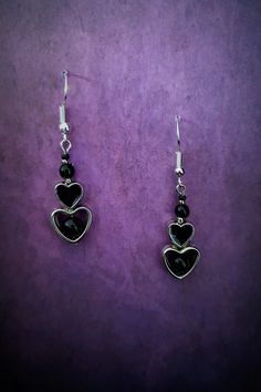 Introducing our stunning Gothic Black Heart Dangle Earrings! These captivating earrings are the perfect accessory for those with a dark and mysterious edge. Crafted with exquisite attention to detail, each earring features a beautifully intricate black heart design, symbolizing passion and intensity. These earrings are lightweight and comfortable to wear, ensuring you can showcase your unique style all day long. Whether you're dressing up for a Gothic-inspired event or simply want to make a statement, these earrings will add a touch of allure and sophistication to any ensemble. Embrace your inner darkness with our Gothic Black Heart Dangle Earrings and let them be a reflection of your unique personality. Each product is one of a kind so there might be slight variations in colour, thickness Dark Feminine Earrings, Black Earrings For Valentine's Day, Black Metal Jewelry For Valentine's Day, Valentine's Day Black Metal Jewelry, Silver Gothic Earrings For Valentine's Day, Black Metal Earrings For Valentine's Day, Black Heart Earrings As A Gift, Black Heart Earrings For Pierced Ears As Gift, Black Sterling Silver Double Heart Jewelry