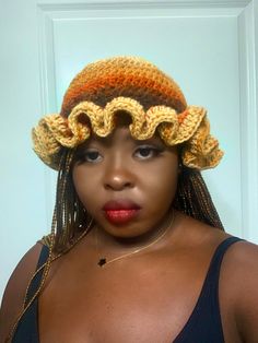 a woman wearing a crocheted hat with braids on her head and lips