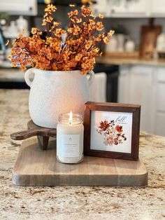 a candle sits next to a vase with flowers in it