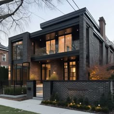 a large brick house with lots of windows on the front and side of it's building