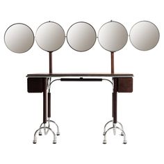 three mirrors are on top of a table with four wheels and one is turned upside down