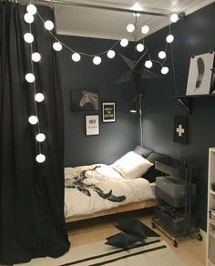 a bedroom with black walls and white lights