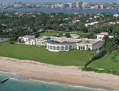 an aerial view of a large white house near the ocean