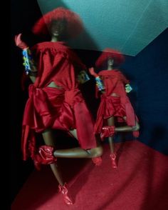 two mannequins dressed in red are posed