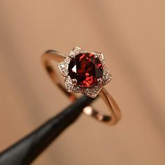 a close up of a ring with a red stone