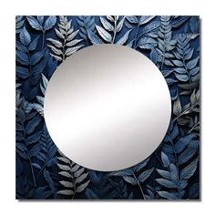 a round mirror sitting on top of a wooden table next to leaves and plants in front of it