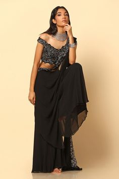 Black and silver hand embroidered attached cancan sharara with attached draped pallu and floral cutwork details. Paired with an embroidered padded blouse.
Components: 2
Pattern: Embroidered
Type Of Work: Nakshi
Neckline: Off-Shoulder
Sleeve Type: Asymmetric
Fabric: Viscose Georgette, Plain Net
Color: Black
Other Details: 
Padded top
Attached cancan
Attached lining
Approx. product weight: 1.5 kg
Length:
Blouse: 14 inches
Sharara: 42 inches
Model Height: 5ft 9inches, wearing size M
Sharara closure Evening Sharara With Traditional Drape, Traditional Drape Sharara For Evening, Evening Traditional Drape Sharara, Draped Sharara For Party, Evening Draped Sharara With Unstitched Blouse, Floor-length Blouse For Diwali Evening, Floor-length Evening Blouse For Diwali, Traditional Floor-length Evening Blouse, Draped Blouse For Diwali Evening