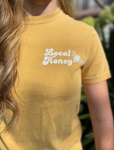 Cute & Comfy Local Honey 🐝 T-shirt ✨Item✨ Unisex t shirt with Local Honey and bee design. Mild yellow colored crew neck shirt with professional heat press lettering  ✨Design✨ you can choose to have the design in plain black or white. Or black or white in glitter. The design in the photos is in Glittler White.  ✨Sizing✨ For best fit, I recommend using the sizing chart. For a loose fit size up. Model in the photo is a size small. These shirts are unisex fit, and fit true to size.  ✨CARE✨ Machine Honey T Shirts, Yellow Short Sleeve T-shirt With Screen Print, Yellow Crew Neck T-shirt With Screen Print, Yellow Crew Neck T-shirt With Text Print, Yellow Crew Neck Top With Screen Print, Yellow Short Sleeve T-shirt With Text Print, Vintage Yellow T-shirt With Text Print, Yellow Cotton T-shirt With Screen Print, Yellow Cotton T-shirt With Text Print