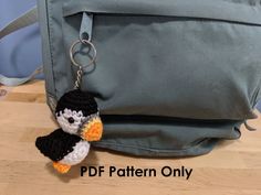 a small penguin keychain hanging from a backpack