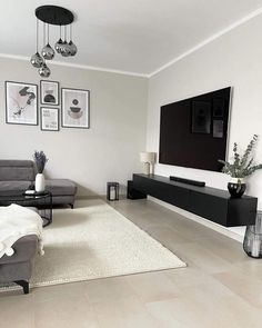 a living room filled with furniture and a flat screen tv mounted to the side of a wall