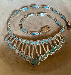 Gorgeous Taxco 925 sterling silver turquoise inlay Mexican bib necklace  Measures: 17 inches long by 1 1/2 inches at its widest point and weighs 60 grams  Marked: Taxco Mexico AMC and the TAXCO Sterling Silver registration number absolutely beautiful!! Unique Blue Necklace With Inlay, Unique Polished Turquoise Necklace, Unique Turquoise Jewelry With Polished Finish, Blue Sterling Silver Necklace With Inlay, Unique Blue Necklace With Polished Finish, Unique Silver Turquoise Necklace With Inlay, Unique Sterling Silver Turquoise Inlay Necklace, Elegant Turquoise Necklace With Inlay, Turquoise Pendant Necklace With Inlay