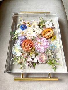 a glass tray with flowers in it on a table