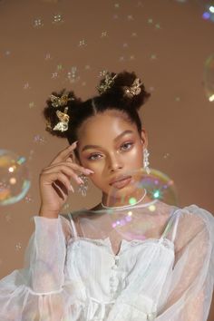 a woman in a white dress with bubbles around her head and hands on her face