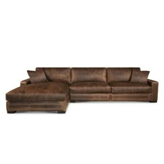 a brown leather sectional sofa with pillows on it's back and footrests