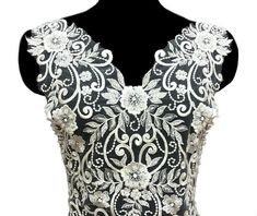 a black and white dress with floral designs on it's chest, in front of a