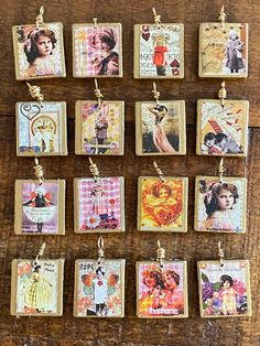 many small tags are hanging on a wooden table with charms attached to the strings that hang from them