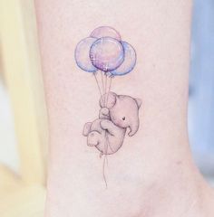 a small elephant holding balloons on the ankle