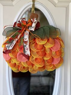 an orange and yellow mesh pumpkin wreath hangs on the front door to give it a festive touch