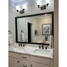 a bathroom with two sinks and a large mirror over it's sink area,